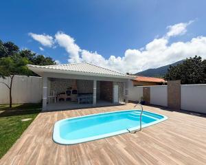 a swimming pool in the yard of a house at House in Jaconé in Maricá