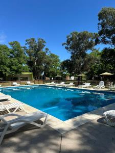 a swimming pool with two lawn chairs and chairs at La Posada de África in Mar del Plata +45 photos