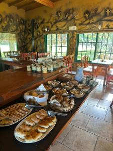a table with a bunch of breads and pastries on it at La Posada de África in Mar del Plata