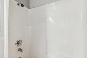 a shower in a bathroom with white walls at Sea Treasures Inn #102 in Rockaway Beach +12 photos