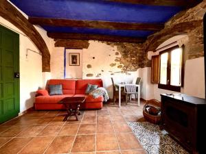 a living room with a red couch and a table at Estudio en masía Can Mon in Anglés +25 photos
