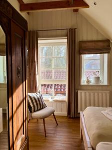 a bedroom with a chair and a window at Ferienwohnung Gänhauk 16 in Löningen
