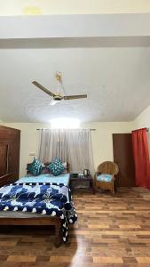 a bedroom with a bed and a ceiling fan at Peaceful Mountain Cottage in Bhīm Tāl +3 photos