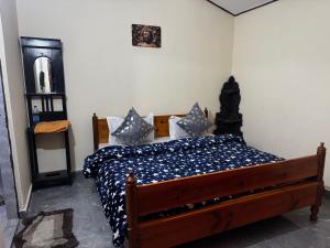 a bedroom with a wooden bed with blue and white pillows at Peaceful Mountain Cottage in Bhīm Tāl
