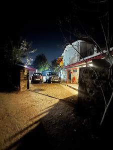 two cars parked in a parking lot at night at Peaceful Mountain Cottage in Bhīm Tāl
