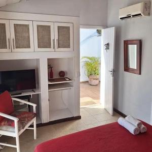 a living room with a television and a door to a patio at Porto Mar de Búzios in Búzios