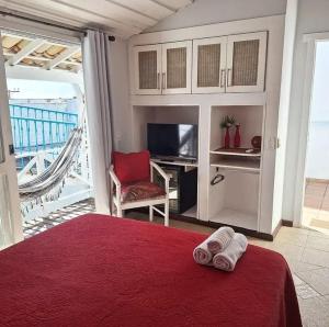 a bedroom with a bed and a desk and a television at Porto Mar de Búzios in Búzios