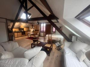 a living room with white couches and a kitchen at Escapade Romantique, Salon cathédrale, Strasbourg in Schiltigheim