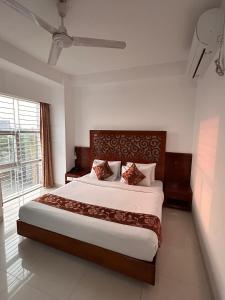 a bedroom with a large bed and a large window at Sylhet La Vista in Sylhet +26 photos