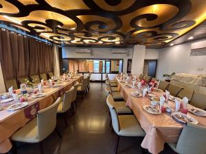 a dining room with long tables and chairs at Sylhet La Vista in Sylhet