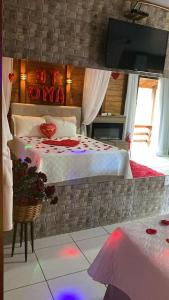 a bedroom with a bed and a tv on a wall at Cabana Amor Perfeito in Alfredo Wagner