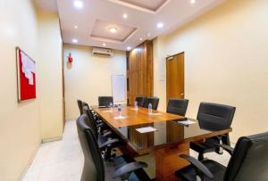 a conference room with a large wooden table and black chairs at Hotel Dream Patna in Patna