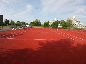 a tennis court with two tennis nets on it at Appartement ‘W Vacantia’ in De Haan