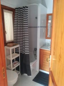 a bathroom with a black and white shower curtain at Apartamentos Punta Mujeres alto derecha in Punta Mujeres