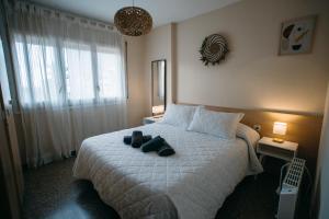 a bedroom with a bed with a pair of shoes on it at Apartamento Floral al centro de Palamós con Wi-Fi in Palamós