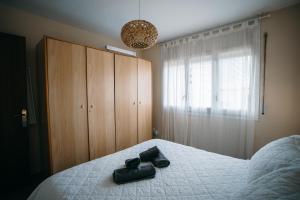 a bedroom with a bed with two black shoes on it at Apartamento Floral al centro de Palamós con Wi-Fi in Palamós