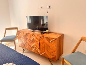 a television on a wooden dresser in a room at Vico Rosso - Milù Holidays La Maddalena in La Maddalena