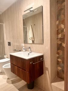 a bathroom with a sink and a toilet and a mirror at Vico Rosso - Milù Holidays La Maddalena in La Maddalena