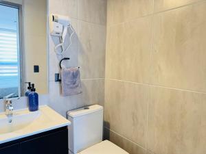 a bathroom with a white toilet and a sink at Muelle Barón - Terminal de Buses in Valparaíso