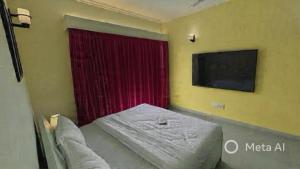 a small bedroom with a bed and a red curtain at 2bhk corporate home in Sohāna
