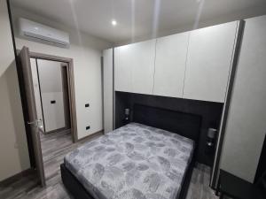 a bedroom with a bed and white cabinets and a mirror at L'Angolo Felice in Riposto