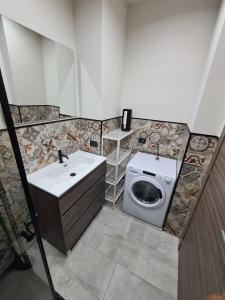 a bathroom with a sink and a washing machine at L'Angolo Felice in Riposto