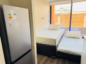 two beds in a room with a window at Muelle Barón - Terminal de Buses in Valparaíso