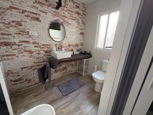 a bathroom with a white sink and a brick wall at Casa Rebeca in Torre de Benagalbón +5 photos