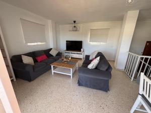 a living room with two couches and a tv at Casa Rebeca in Torre de Benagalbón