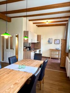 a kitchen and dining room with a wooden table and chairs at Ferienwohnung Gänhauk 16 in Löningen