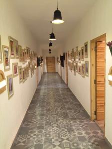 Un pasillo vacío con fotos en las paredes y un pasillo cerrado en RAJA KA BAGH - A Boutique Hotel, en Nūrpur