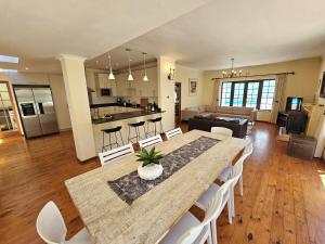 a dining room and living room with a table and chairs at The Gables in Hout Bay