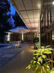 a patio with a table and chairs and an umbrella at TheMalkohaVilla in Umsning