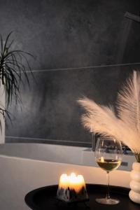 a candle and a glass of wine on a table at Sweet Home Tskaltubo Family Guesthouse Near Spa Park in Tsqaltubo +69 photos