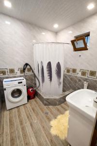 a bathroom with a washing machine and a sink at Sweet Home Tskaltubo Family Guesthouse Near Spa Park in Tsqaltubo