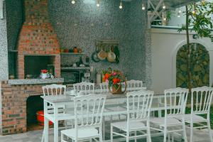 a dining room with a table and white chairs at Huế Silk Homestay in Cồn Giả Viên
