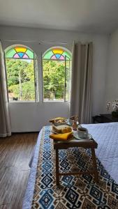 a room with a table and two stained glass windows at Pousada Villa Real in Sabará +75 photos