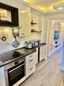 a kitchen with white cabinets and a stove top oven at Im Point von Kiel City in Kiel