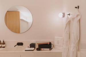 a bathroom counter with a mirror and a sink at Casa Ofelia in Mexico City