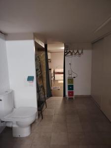 a bathroom with a toilet and a room with a bed at bords de loire in Saint-Sébastien-sur-Loire