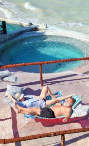 two people laying on towels next to a swimming pool at On Beach Seaside Sunset Haven 2 - Epic Sea View in Chuburná +68 photos