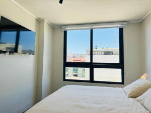 a bedroom with a bed and a large window at Terminal de Buses - Centro de Valparaíso in Valparaíso
