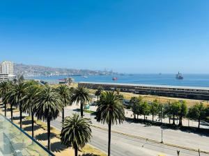 a view of a street with palm trees and the ocean at Terminal de Buses - Centro de Valparaíso in Valparaíso
