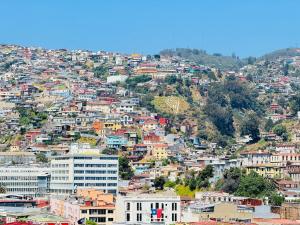 a view of a city with buildings on a hill at Terminal de Buses - Centro de Valparaíso in Valparaíso +10 photos