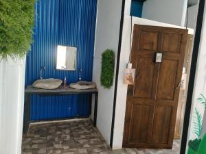 a bathroom with a sink and a wooden door at Casa Concha Golfito in Golfito +8 photos