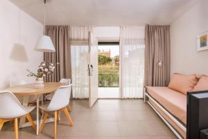 a small apartment with a dining table and a couch at Apartamentos Castellmar in Castelldefels