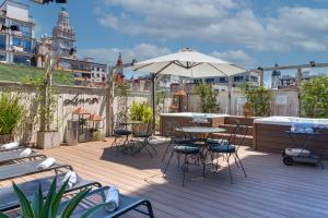 a deck with tables and chairs and an umbrella at Lennox Buenos Aires in Buenos Aires
