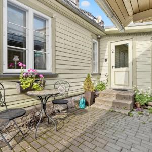 a patio with a table and chairs in front of a house at Wiedemanni Apartments in Haapsalu