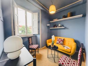 a living room with a yellow couch and chairs at Luxury Apartment in Lucca in Lucca