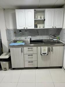 a kitchen with white cabinets and a sink at Turismo y Comercio a 5min I Ubicación estratégica in Manizales +4 photos